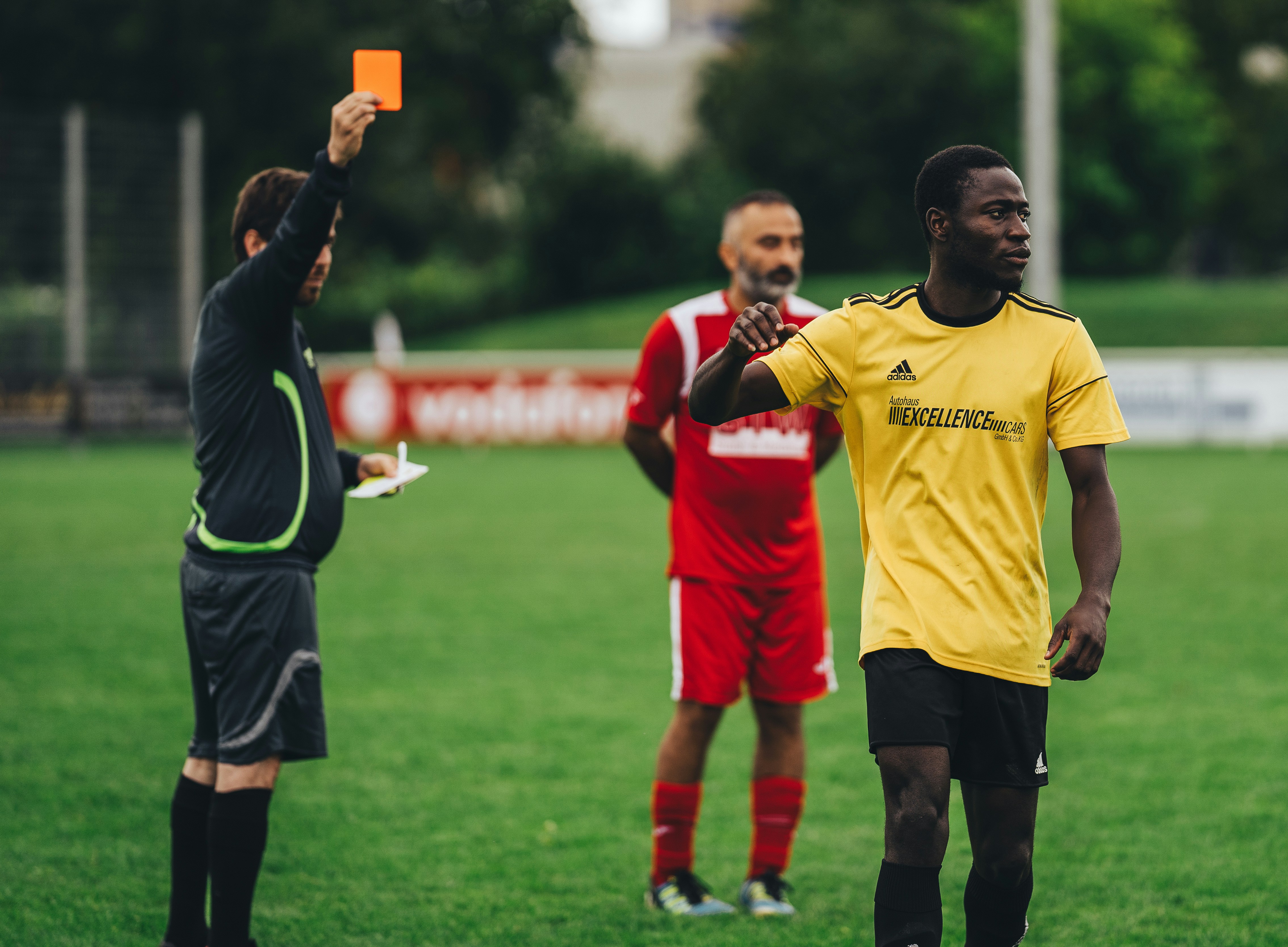 An image of a referee giving a red card to a player